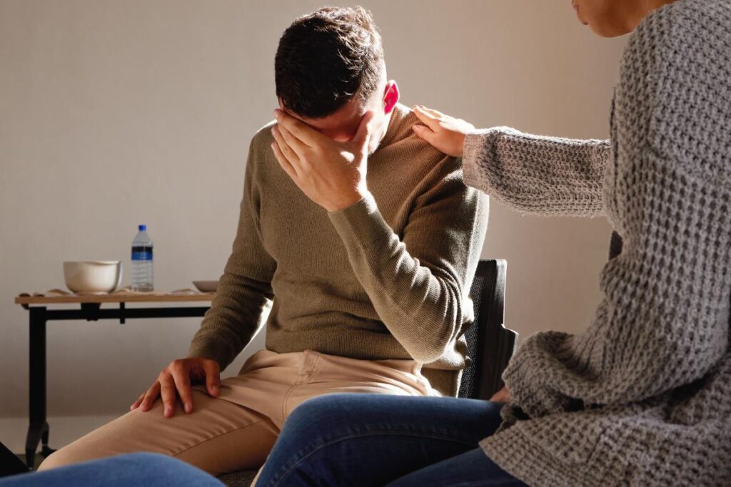 a person puts their head in their hands as they struggle with heroin abuse