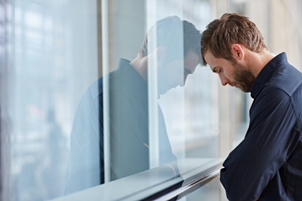 a person puts their head on a window to show high functioning anxiety and depression