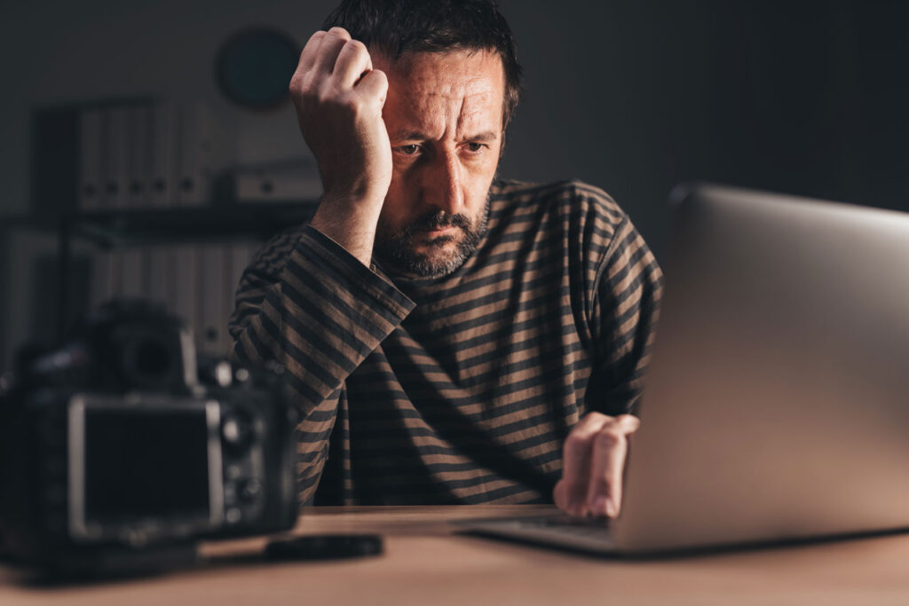 Man sits at computer and struggles to focus as he is living with anxiety