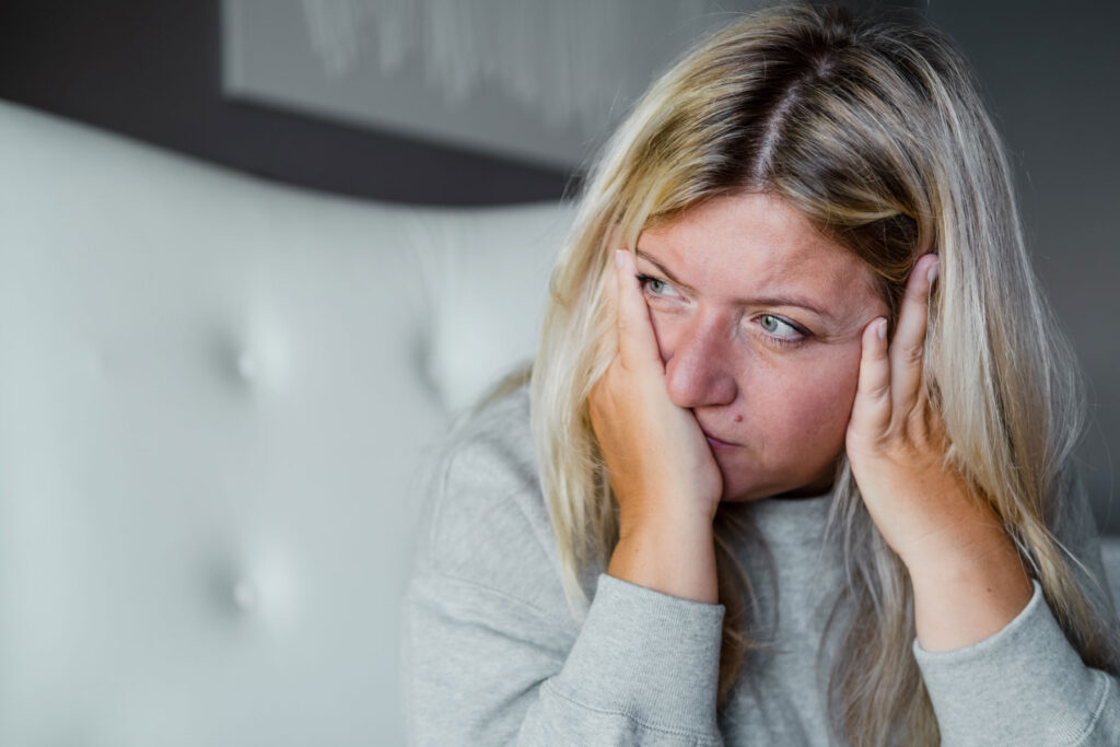 Woman rubs face as she wonders what to do after a relapse